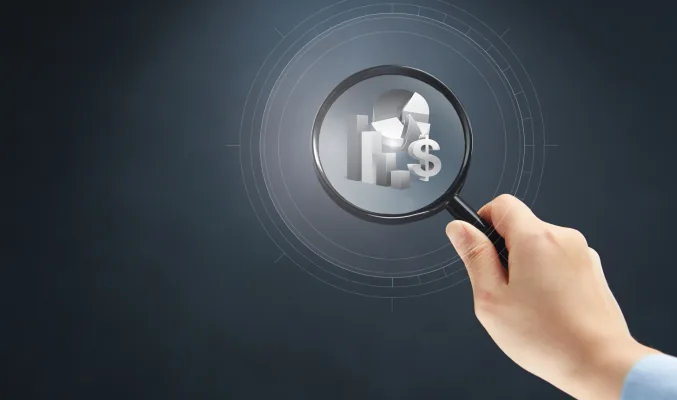 magnifying glass examining postcards with financial symbols